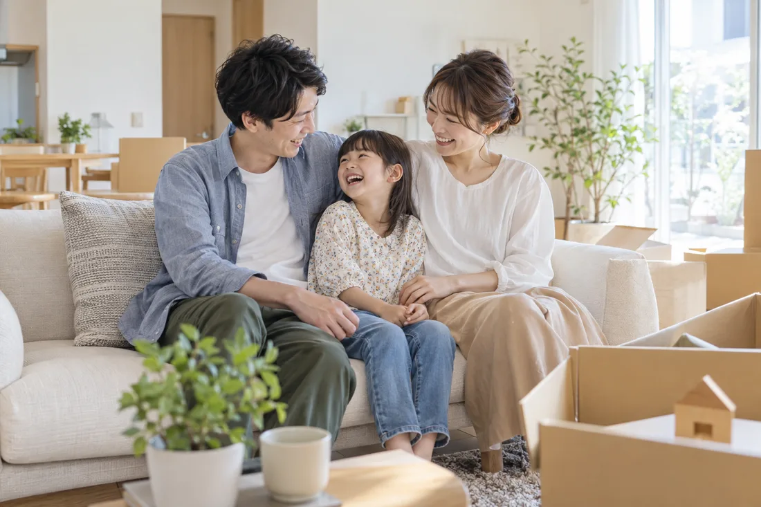 明るい新居で笑顔を交わす家族の暮らしのイメージ
